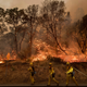 Firefighters battle a wildfire as it threatens to jump a street near Oroville, California. Evening winds drove the fire through several neighborhoods leveling homes in its path. (Image: AP/Noah Berger)